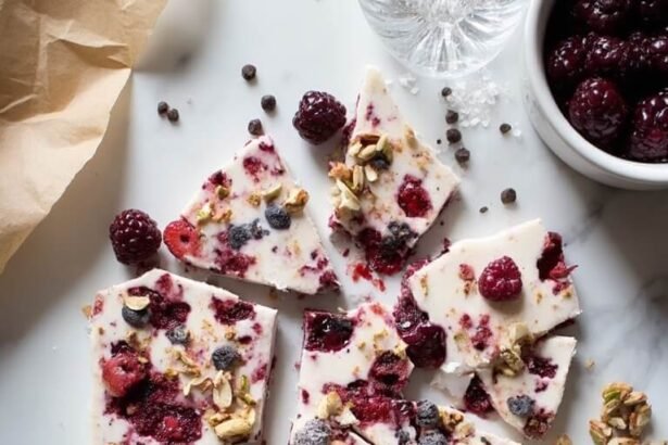 "Overhead view of high-protein frozen Greek yogurt bark with mixed berries, nuts, chocolate on a marble countertop"
