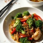 "Asian keto chicken stir-fry with broccoli, bell peppers, and bok choy served with miso soup featuring tofu and wakame seaweed, shot in a professional food photography style."