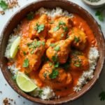 "Overhead view of spicy keto chicken tikka masala with cauliflower rice and fresh cilantro lime garnish, on a clean marble background"