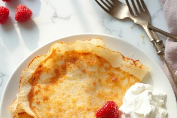 "Golden coconut flour crepes with fresh berries and whipped cream on a white porcelain plate, presented on a clean marble background"