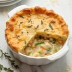 "Golden-brown low-carb chicken pot pie with almond flour crust on a clean marble surface"