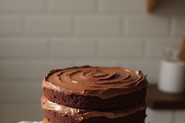 "Triple-layer keto chocolate cake with buttercream frosting on white ceramic stand, with ingredients scattered around"