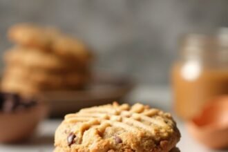"Stack of almond butter keto cookies with chocolate chips on a clean marble background"