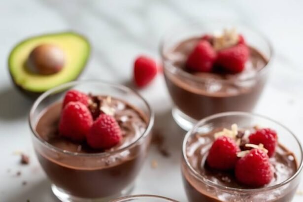 "Overhead view of dark chocolate avocado mousse in glass bowls garnished with raspberries and chocolate shavings on a white marble background"