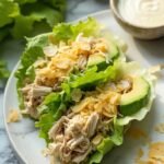 "Keto chicken Caesar wraps with avocado and Parmesan crisps on a white marble countertop"